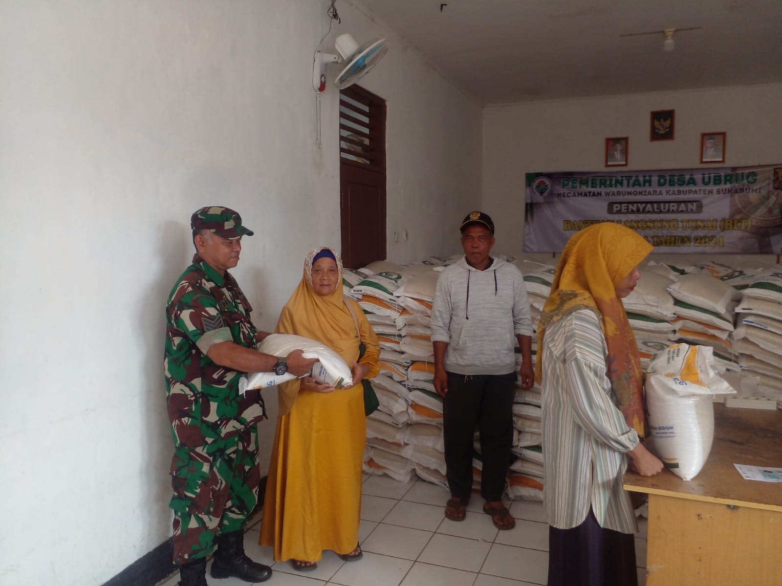 Babinsa Ubrug Koramil 2203/Warungkiara, Serka Endan melaksanakan pendampingan pendistribusian beras. Foto: Ist